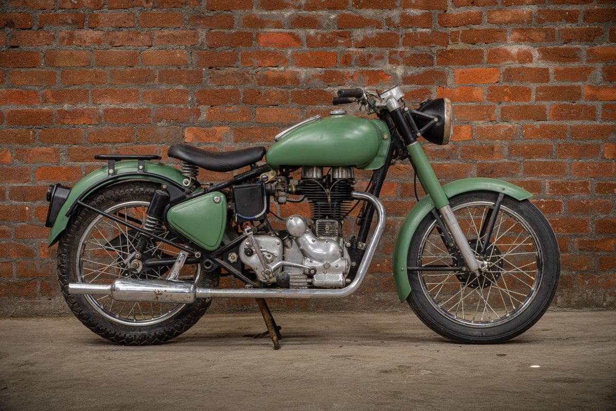 Green 1959 Royal Enfield Bullet 350 parked against a brick wall