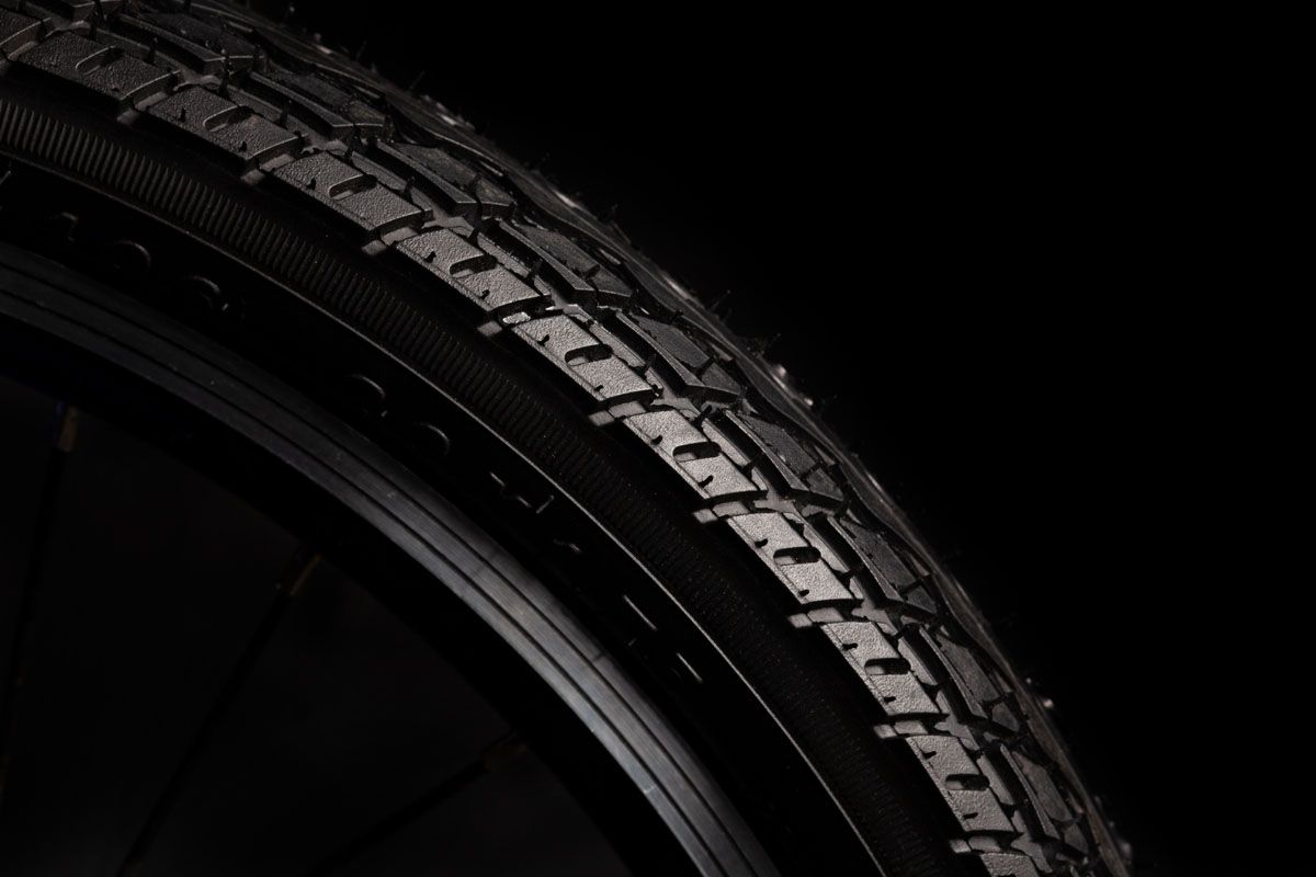 Close-up of a bicycle tyre tread lit against black
