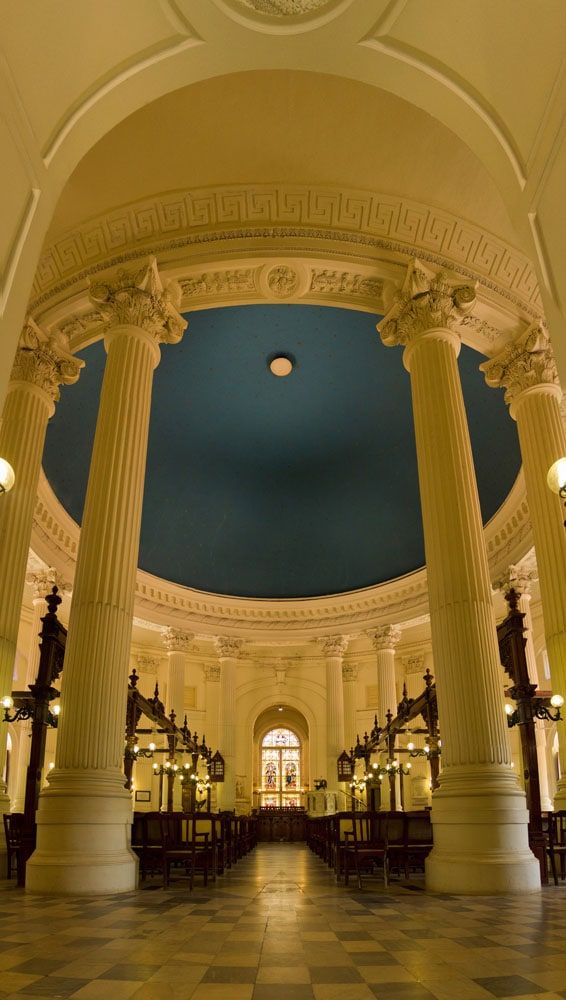 Domed heritage hall with tall white columns and a painted blue ceiling