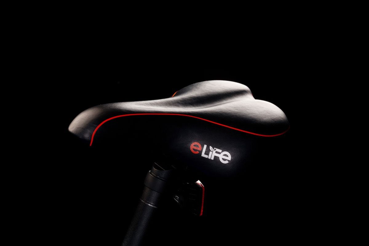 Black eLife bicycle saddle with a red trim line, against black