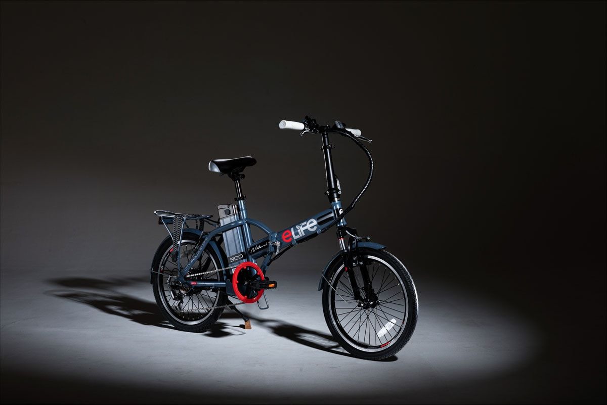 Grey eLife folding electric bicycle in a spotlight on a dark studio floor