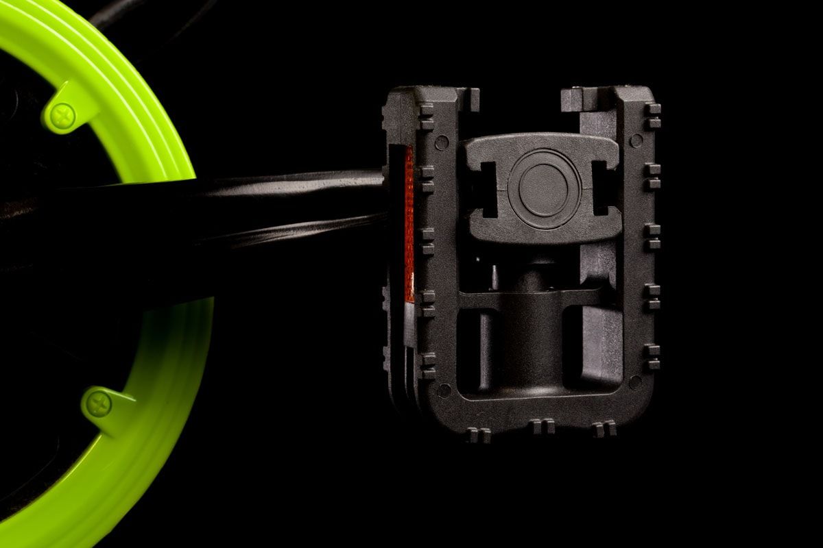 Folding bicycle pedal beside a lime-green wheel, against black