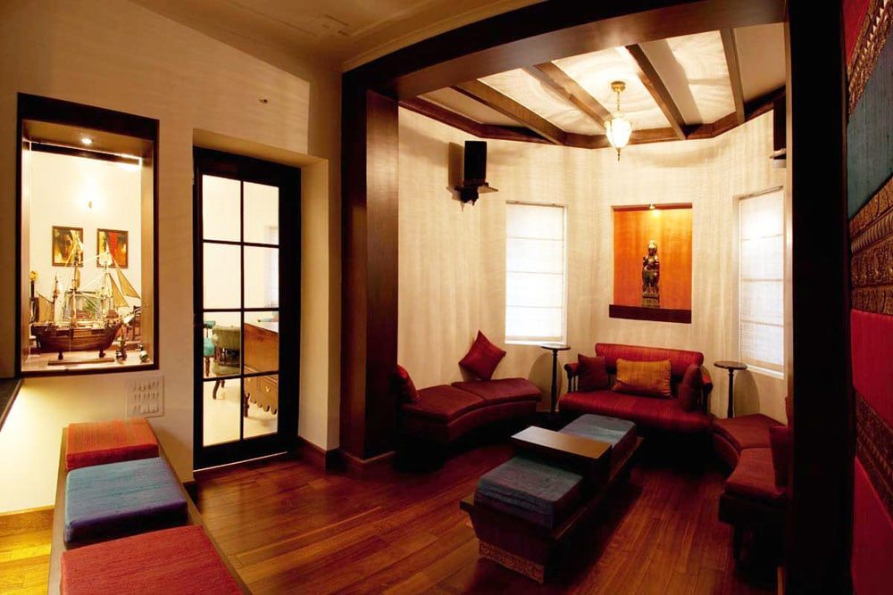 Heritage lounge with red sofas, a timber ceiling and a ship model in a glass case