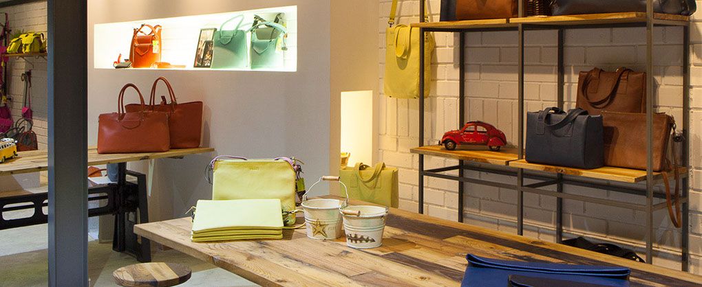 Leather bags displayed on wooden shelving in the Viari showroom, Chennai